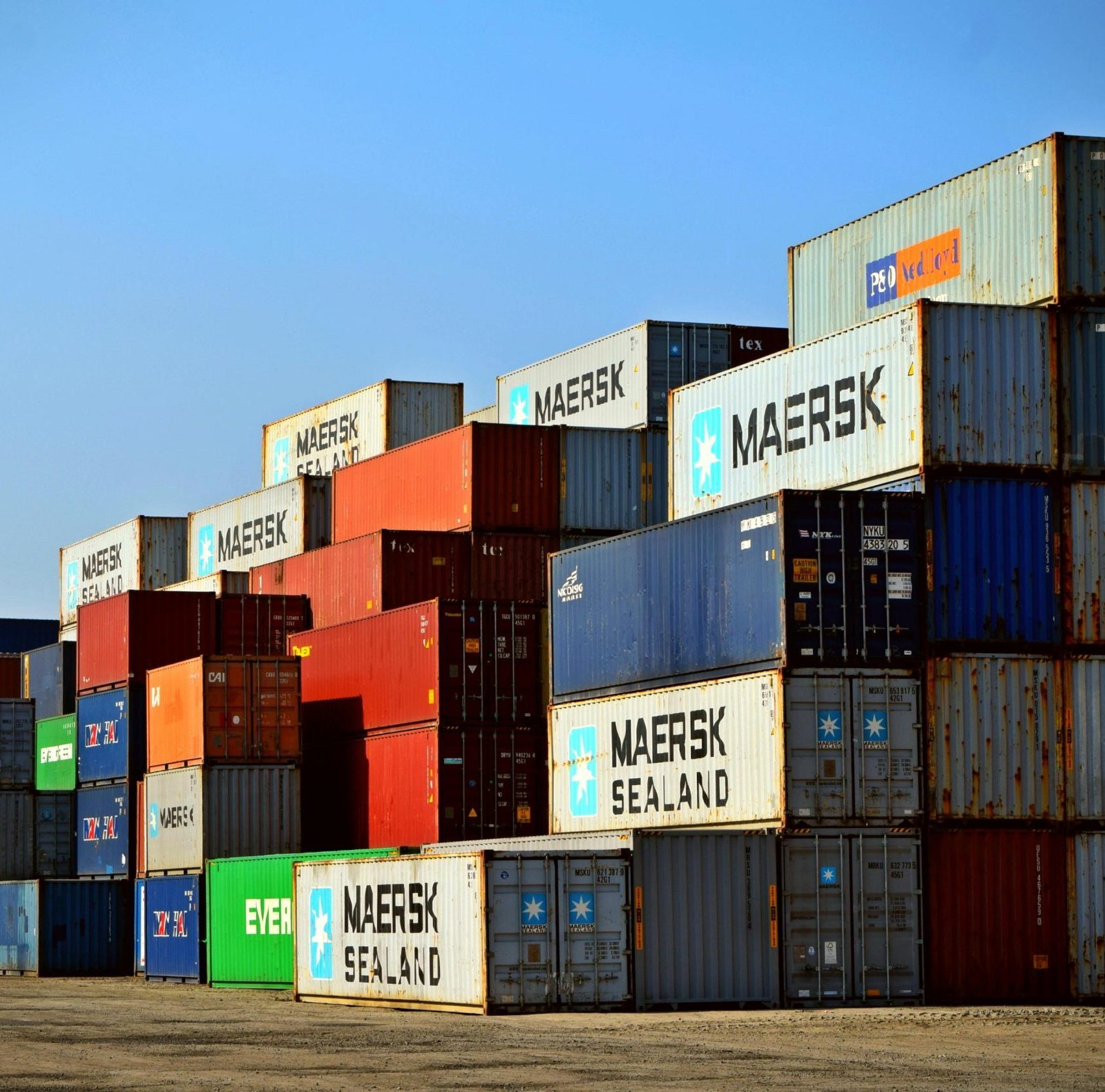 Colorful stacked shipping containers at a port exemplify global logistics.
